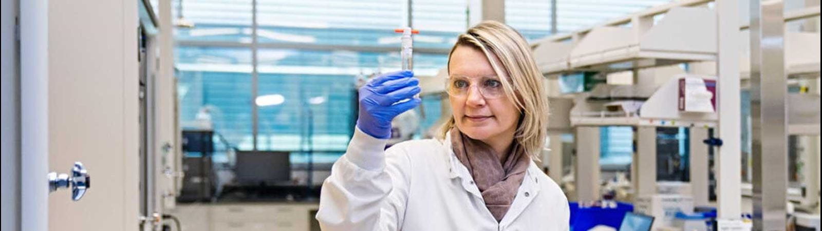 Bir test tüpü tutan CSL çalışanı