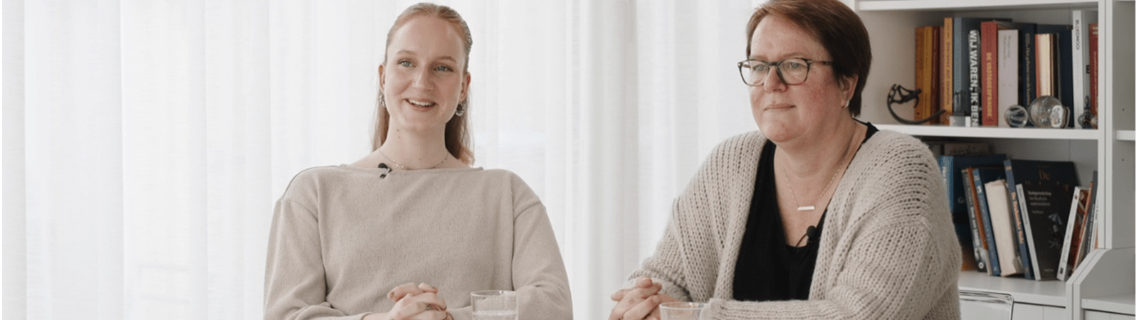 Anne ve yetişkin kızı masada oturuyor